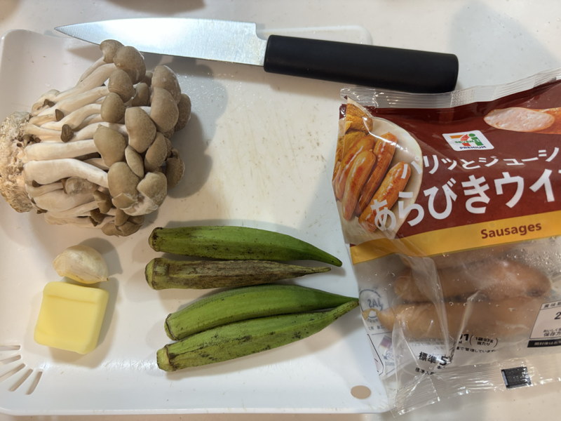 まな板に並べたしめじ、オクラ、にんにく、バター、あらびきウインナー