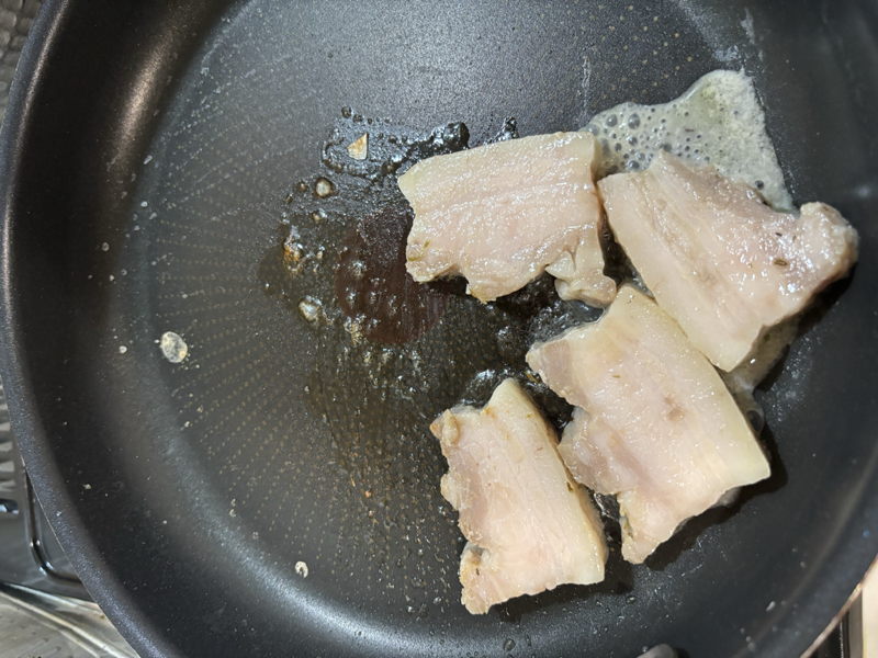 裏返して焼いている豚バラコンフィ