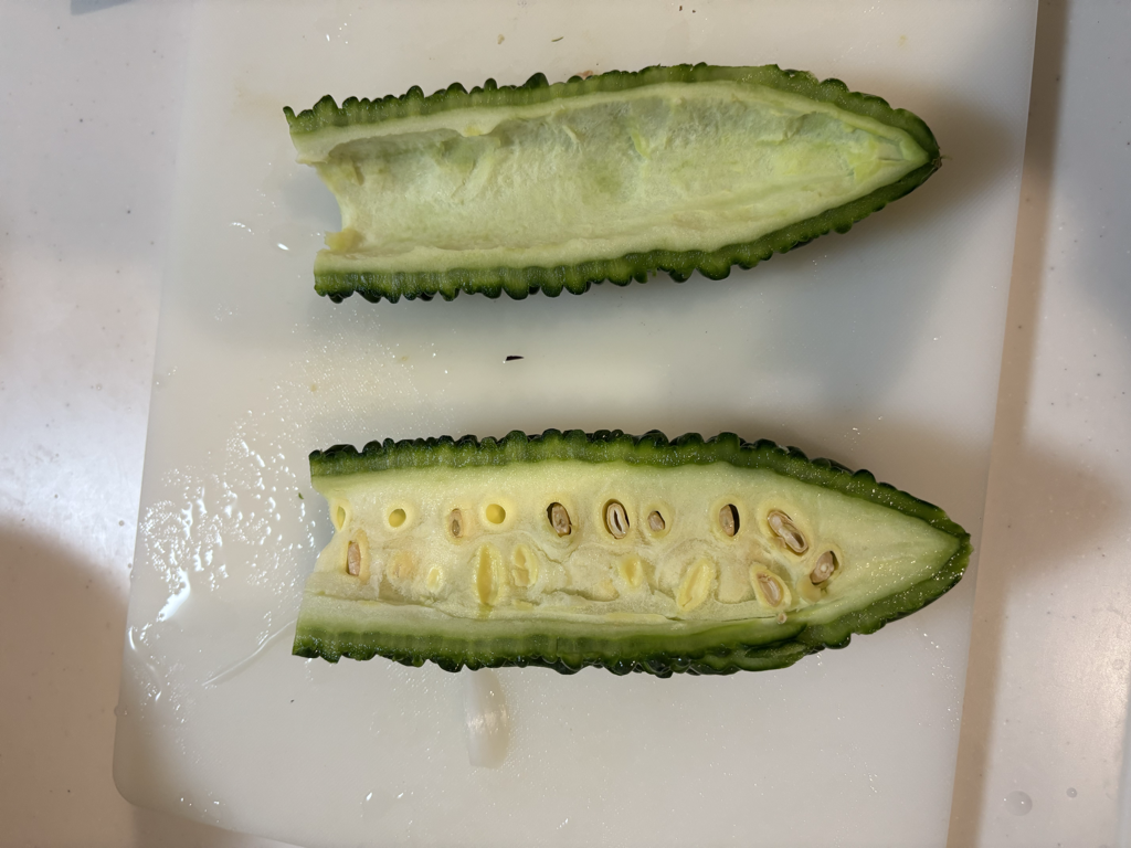 ヘタを取り除いて半分にカットされたゴーヤの断面が見える様子